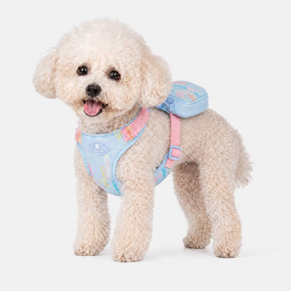 Bichon Frise standing in the PocketCharm Harness in pastel blue, signature mini back pouch visible on top.